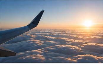 Flyvinge over skyer ved solopgang